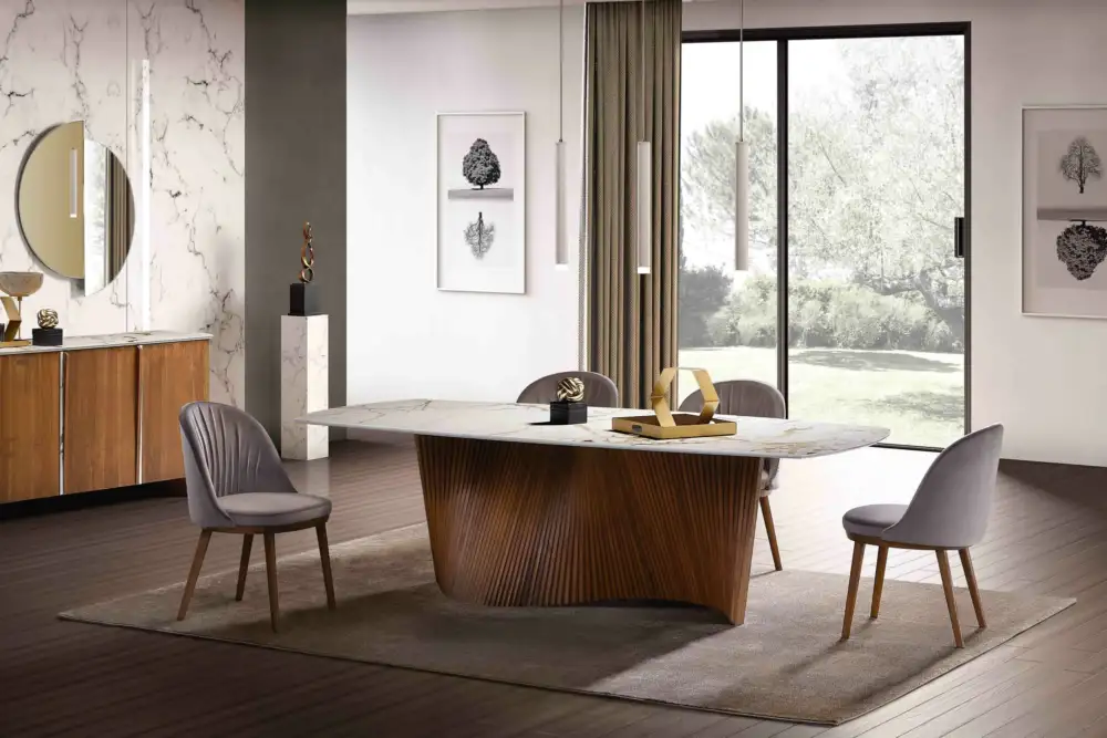 Modern dining room featuring the ORBIT dining table with a marble-look top and sculptural timber base. Paired with grey velvet dining chairs and a matching sideboard, this elegant space blends contemporary design with natural textures. Shop designer dining tables at Bradfords.